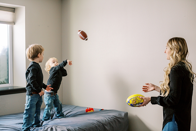 Mom throwing footballs with her boys